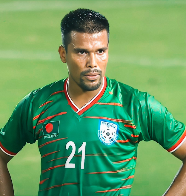 Ein Mann in einem grünen T-Shirt steht auf einem Fußballfeld während eines Spiels, mit einem unscharfen Hintergrund und Text, der unten 'Bangladesh vs India Live Streaming' lautet.