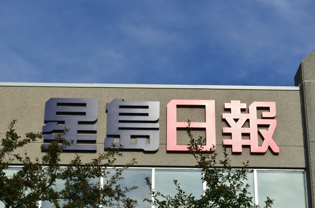 Ein Gebäude mit einem Schild, auf dem "Shenzhen Zhejiang Technology Co., Ltd." steht, umgeben von Bäumen unter einem klaren blauen Himmel.