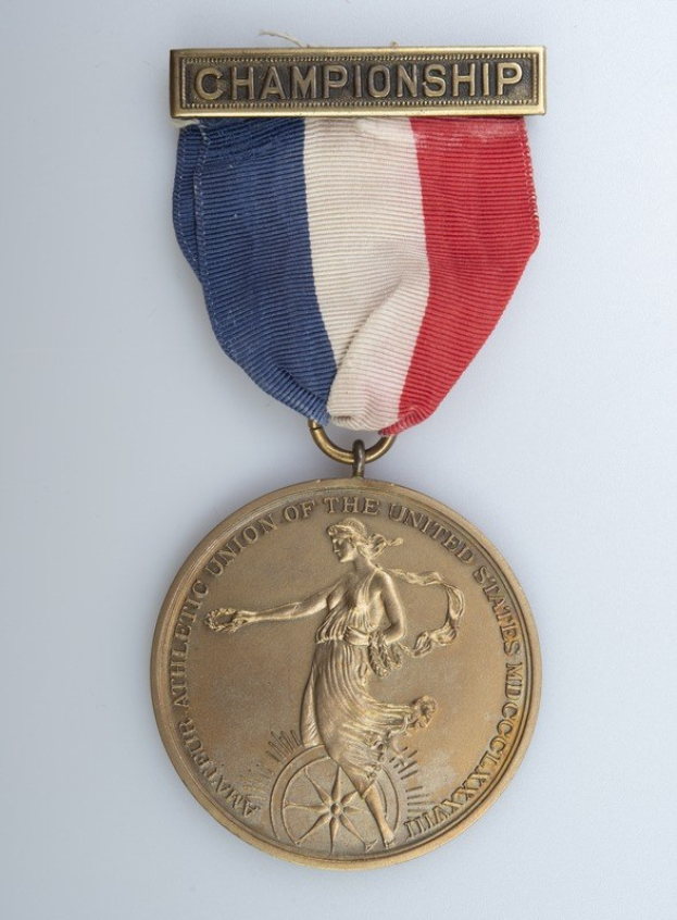 Goldmedaille mit rot-weiß-blauem Band, geprägt mit 'Championship' und einem Personenbild.