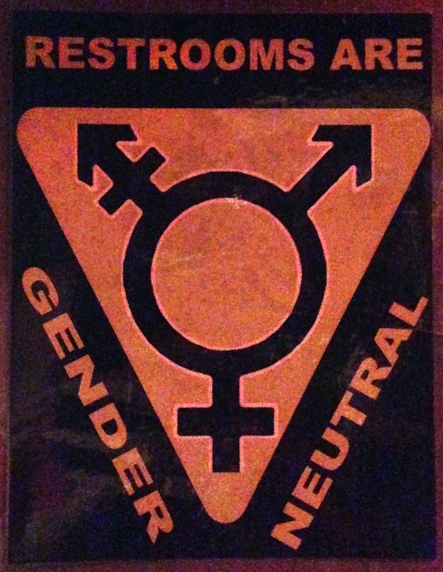 Ein Plakat mit der Aufschrift 'Toiletten sind geschlechtsneutral' betont die Bedeutung des Geschlechts in der Toilette.