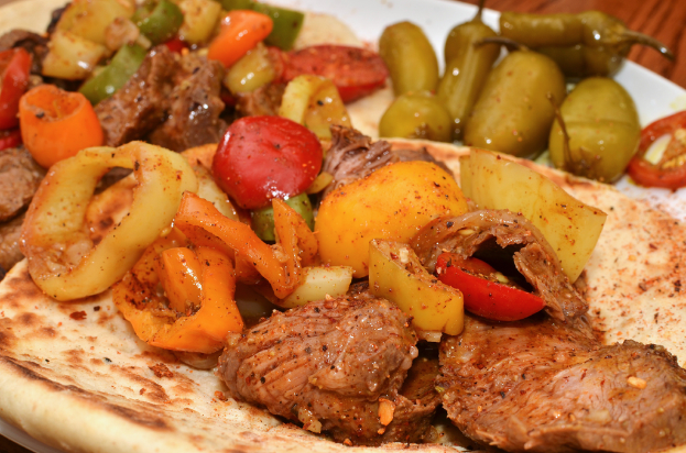 Ein Teller mit Tomaten, Chilischoten und Hühnerstücken.