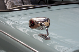 Eine Nahaufnahme eines Autos Seitenspiegels, der am Fahrzeug befestigt ist und die Umgebung reflektiert, verleiht dem Auto ein elegantes und modernes Aussehen.