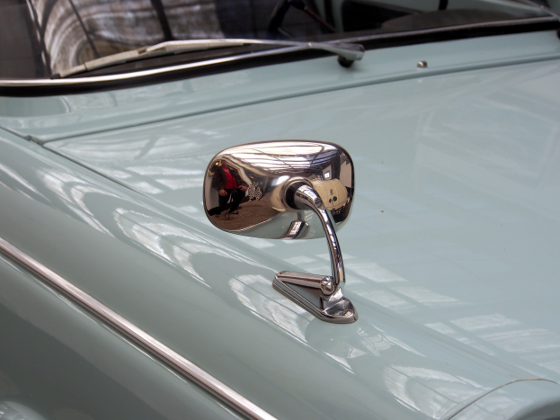 Eine Nahaufnahme eines Autos Seitenspiegels, der am Fahrzeug befestigt ist und die Umgebung reflektiert, verleiht dem Auto ein elegantes und modernes Aussehen.