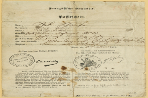 Ein altes, vergilbtes Dokument mit einem kreisrunden, schwarz umrandeten Stempel, wahrscheinlich ein Brief der deutschen Regierung, geschrieben in schwarzer Tinte.