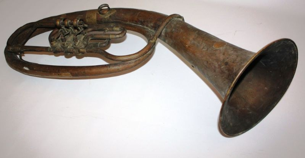 Alter Messinghorn mit glänzendem Finish, gebogenem Hals und aufgeblähtem Schalltrichter, verziert mit kunstvollen Gravuren, auf einem weißen Hintergrund.