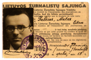 Ein alter Pass mit einem Foto eines Mannes mit Brille, einem Stempel und Text, der persönliche Informationen enthält.